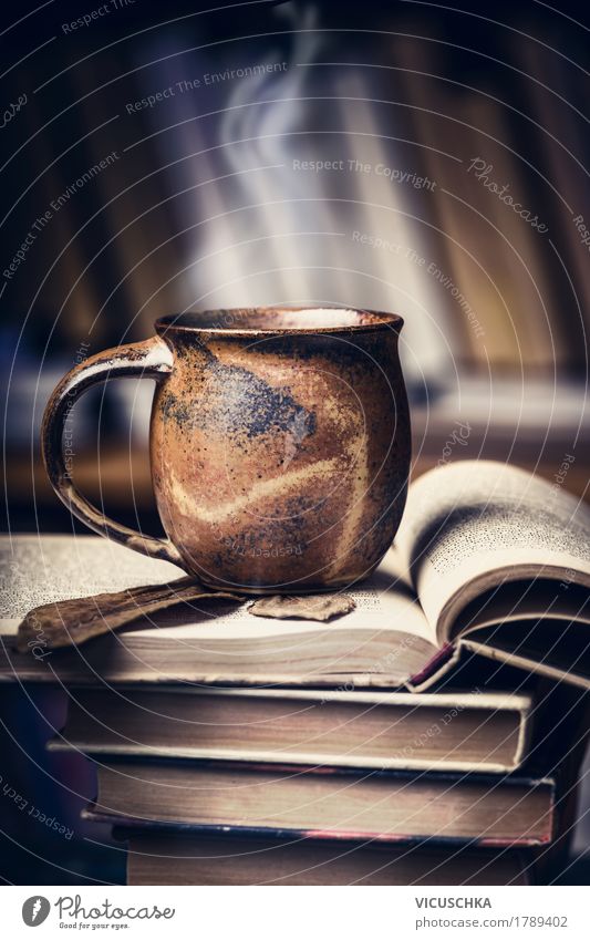 Tasse mit heißem Getränk auf Bücher Stapel Heißgetränk Kakao Kaffee Tee Lifestyle Stil Design Häusliches Leben Tisch Bildung lernen retro altehrwürdig Buch