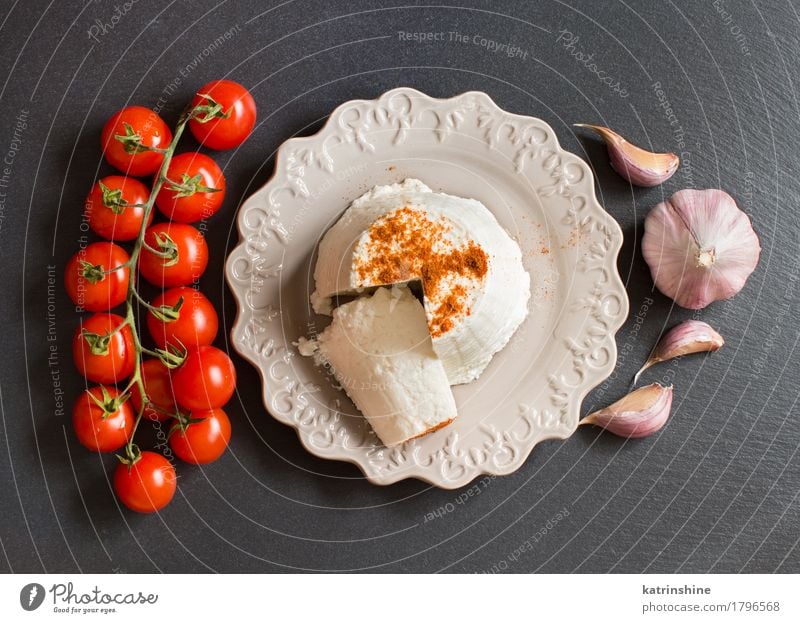 Italienischer Ricottakäse, Knoblauch und Kirschtomaten Käse Milcherzeugnisse Gemüse Ernährung Diät Italienische Küche Teller dunkel frisch rot weiß