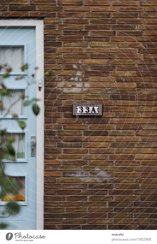 hier wohnt... Dorf Stadt Haus Einfamilienhaus Mauer Wand Fassade Tür Namensschild Stimmung Hausnummer Häusliches Leben Niederlande Bauweise alt Altbau Farbfoto