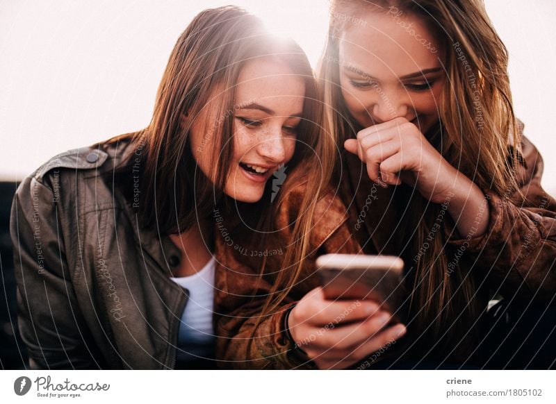 Glückliche Jugendlichmädchen, die das intelligente Telefon betrachtet Bilder verwenden Lifestyle Technik & Technologie Unterhaltungselektronik Telekommunikation