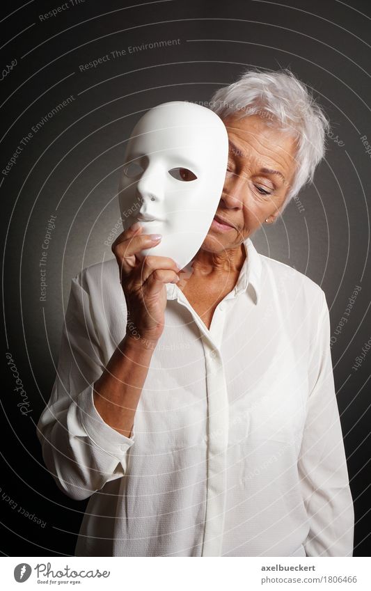 Reife Frau, die trauriges Gesicht hinter Maske revaling ist Mensch Erwachsene Weiblicher Senior 1 60 und älter Schauspieler Traurigkeit weiß Gefühle Identität