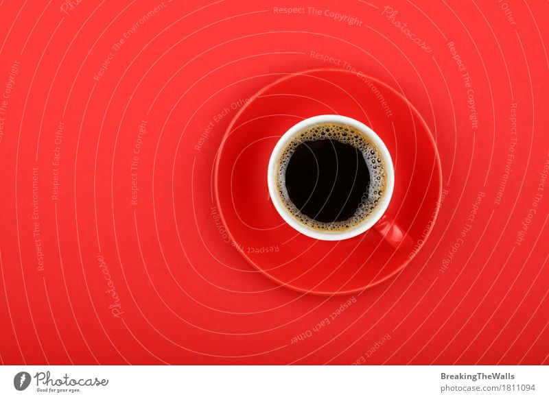 Schwarzer Kaffee in der roten Schale mit Untertasse auf rotem Papier, Draufsicht Frühstück Kaffeetrinken Getränk Heißgetränk Becher genießen Aggression stark