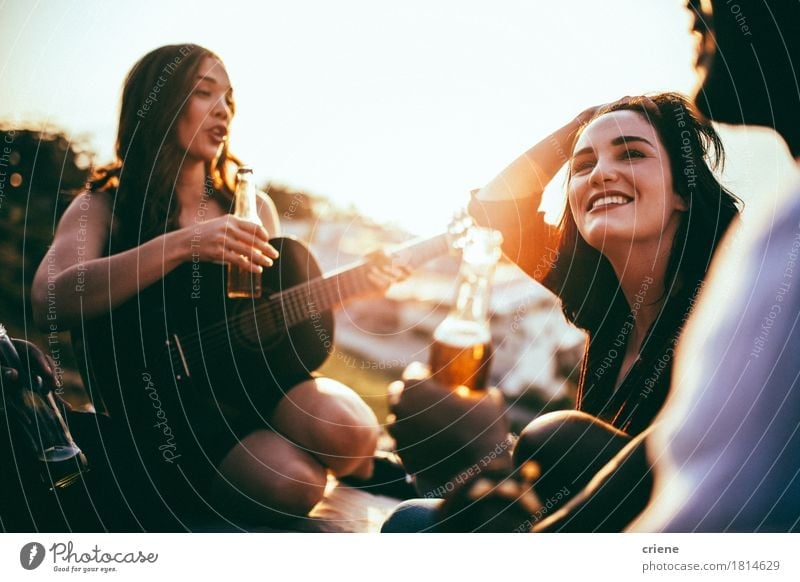 Freunde, die Picknick haben und Musik hören, spielten auf Gitarre Getränk Alkohol Bier Flasche Lifestyle Freude Sommer Sommerurlaub Garten Party ausgehen