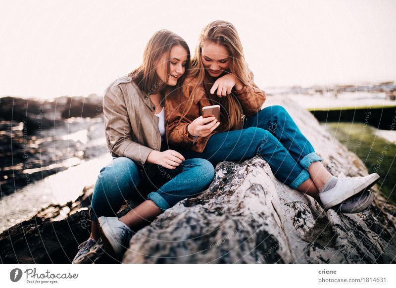 Glückliche junge Jugendlichmädchen, die intelligentes Telefon betrachten Lifestyle Freude Freiheit Strand Meer Handy PDA Technik & Technologie