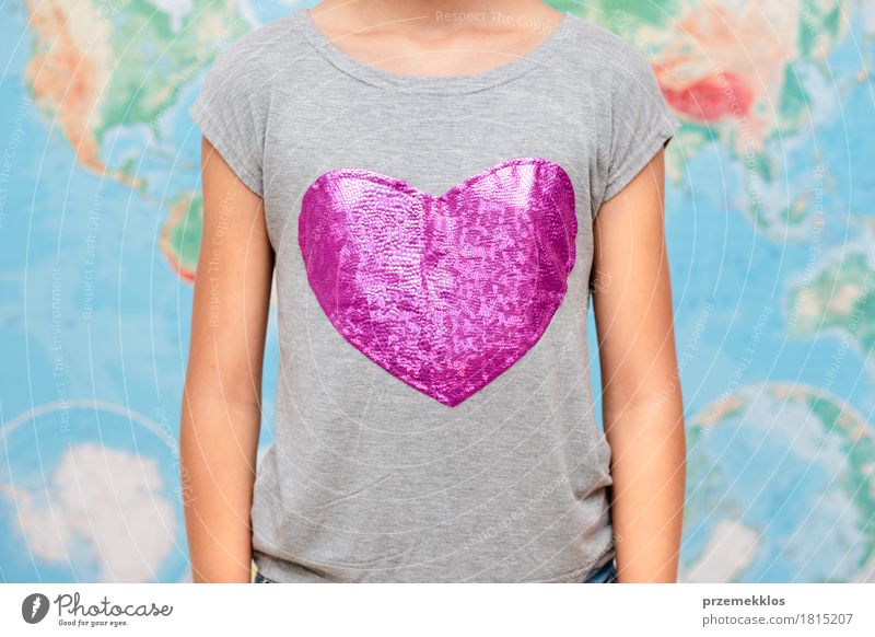 Mädchen mit Herzform auf T-Shirt mit Karte im Hintergrund 1 Mensch 13-18 Jahre Jugendliche Globus Liebe frei Freundlichkeit Fröhlichkeit gut rosa Optimismus