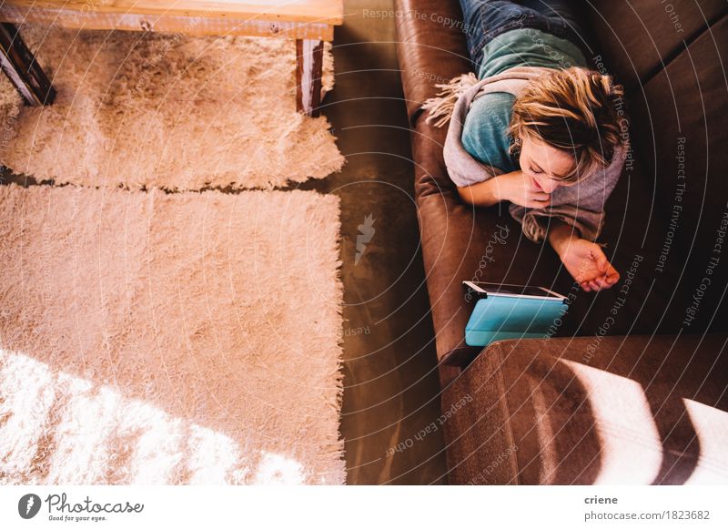 Reife erwachsene Frau auf dem Sofa, das E-Buch auf digitalem Tablet liest Lifestyle lesen Wohnzimmer Technik & Technologie Telekommunikation