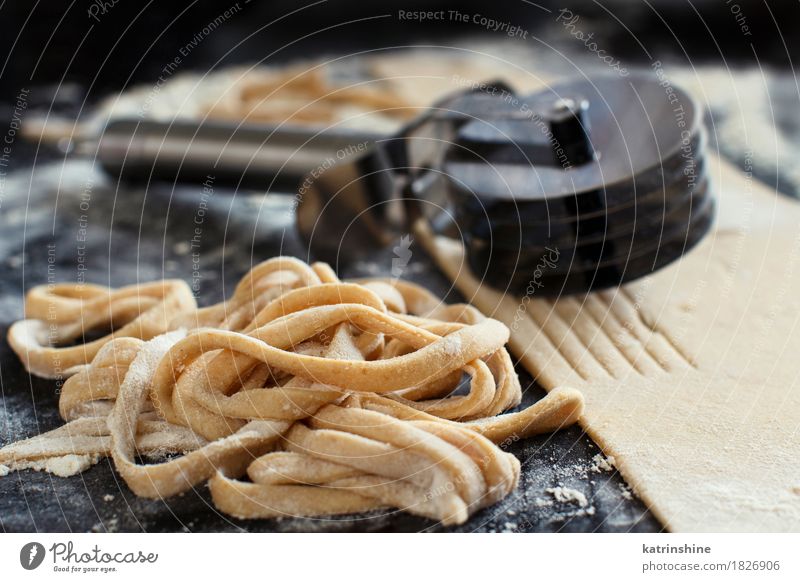 Making hausgemachte Taglatelle mit einer Pasta Rollschneider Teigwaren Backwaren Ernährung Italienische Küche Tisch Werkzeug machen dunkel frisch Tradition