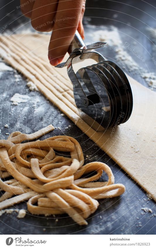 Making hausgemachte Taglatelle mit einer Pasta Rollschneider Teigwaren Backwaren Ernährung Italienische Küche Tisch Werkzeug dunkel frisch Tradition Zutaten