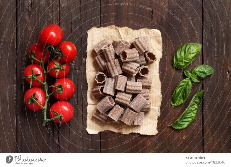 Rohe italienische Teigwaren-, Basilikum- und Kirschtomaten Gemüse Backwaren Kräuter & Gewürze Ernährung Vegetarische Ernährung Diät Italienische Küche Tisch
