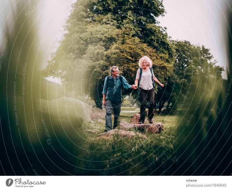 Reifes Paar, das im Urlaub grüne Felder der Wanderrinne kreuzt Lifestyle Freude Erholung Freizeit & Hobby Ferien & Urlaub & Reisen Abenteuer wandern Ruhestand