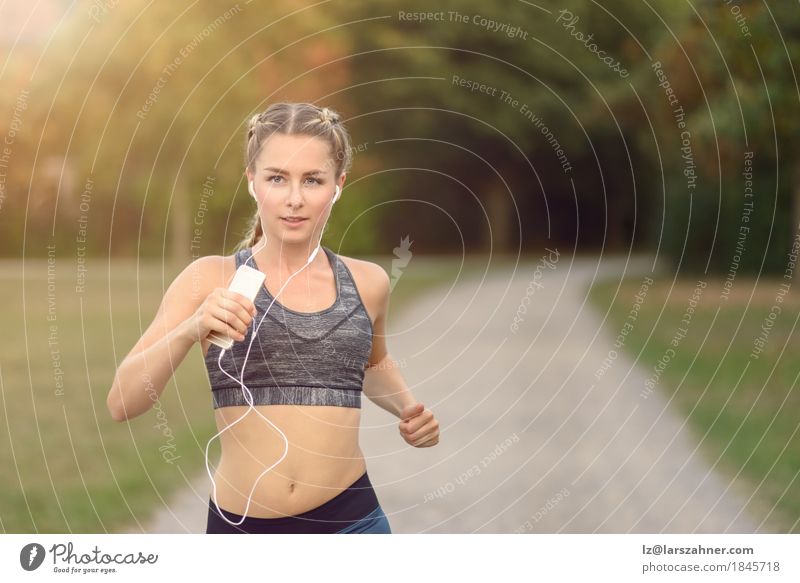 Frau, die entlang einer Landstraße beim Hören Musik rüttelt Lifestyle Sommer Sport Joggen PDA feminin Erwachsene 1 Mensch 18-30 Jahre Jugendliche Landschaft