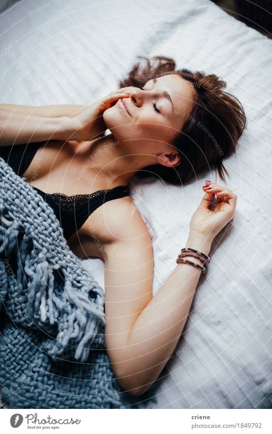 Junge lächelnde Frauen, die in bequemes Bett legen Lifestyle Freude Körper Gesicht Erholung Häusliches Leben Wohnung Möbel Schlafzimmer Junge Frau Jugendliche