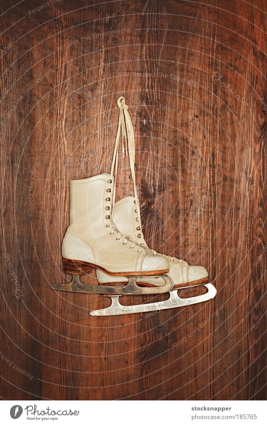 Alte Schlittschuhe Schlittschuhlaufen Eis alt weiß altehrwürdig abgenutzt Leder Schuhe Sport erhängen Wand hölzern paarweise
