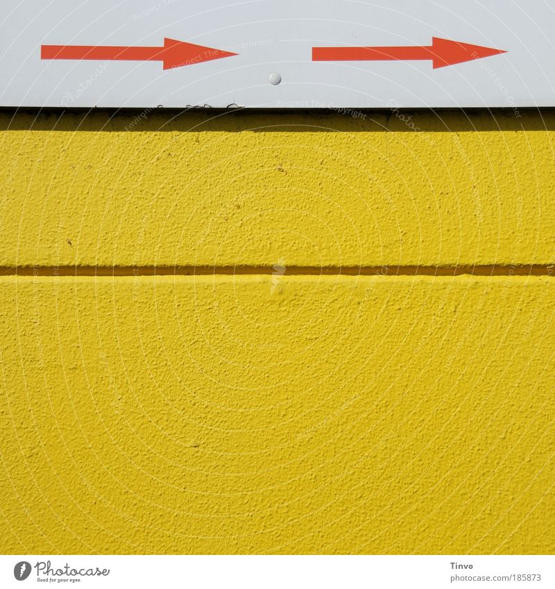 -> . -> Mauer Wand gelb rot weiß graphisch Pfeile Schilder & Markierungen Richtung richtungweisend Furche Außenwand Farbfoto Außenaufnahme Menschenleer