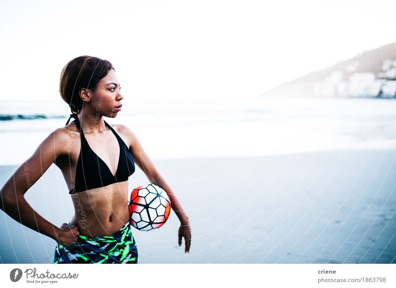 Afrikanischer weiblicher Athlet, der Fußball in den Händen hält Lifestyle schön Körper sportlich Fitness Erholung Freizeit & Hobby Spielen Strand Sport