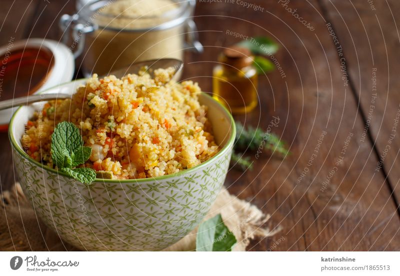 Couscous mit Garnelen und Gemüse in einer Schüssel Meeresfrüchte Getreide Mittagessen Abendessen Schalen & Schüsseln Löffel braun gelb Tradition Afrika