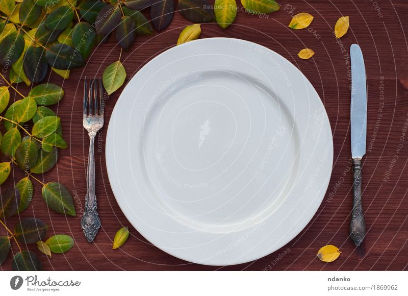 Leeren Sie weiße Platte, Messer und Gabel auf brauner Holzoberfläche Mittagessen Teller Tisch Küche Restaurant Blatt Metall leer Tabelleneinstellung Zweig