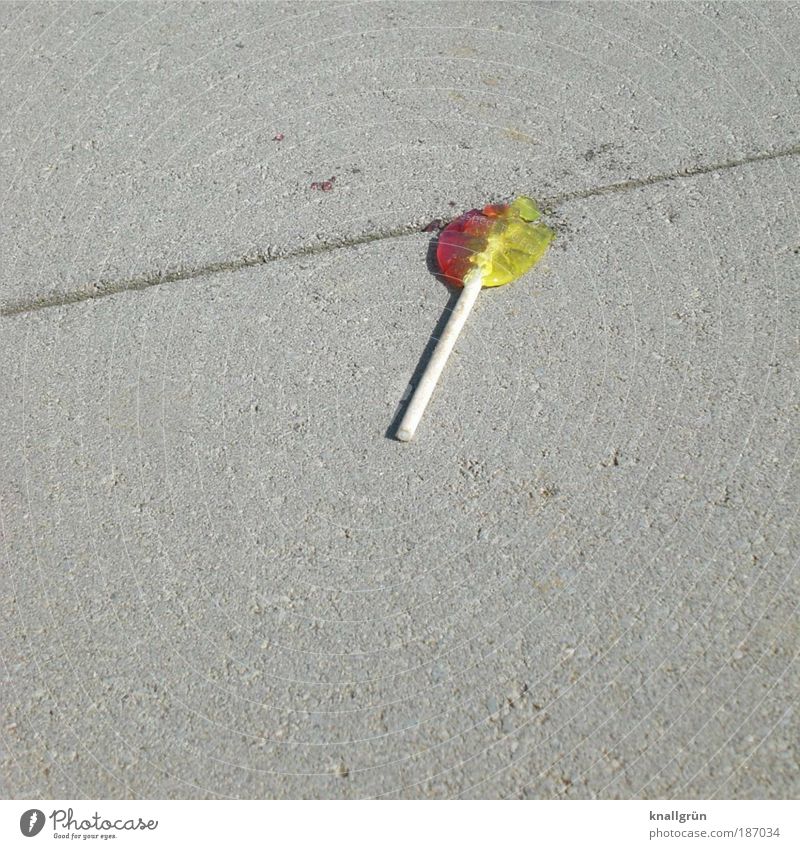 Lutscher Lebensmittel Süßwaren Dauerlutscher Lollipop liegen kaputt lecker rund süß gelb grau rot weiß verschwenden Einsamkeit Kindheit Verfall Reichtum Boden