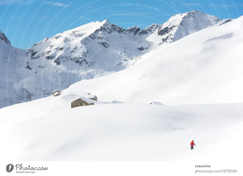 Snowboarder geht bergab über eine verschneite Berglandschaft Ferien & Urlaub & Reisen Winter Schnee Berge u. Gebirge Sport Junge Himmel Alpen frieren