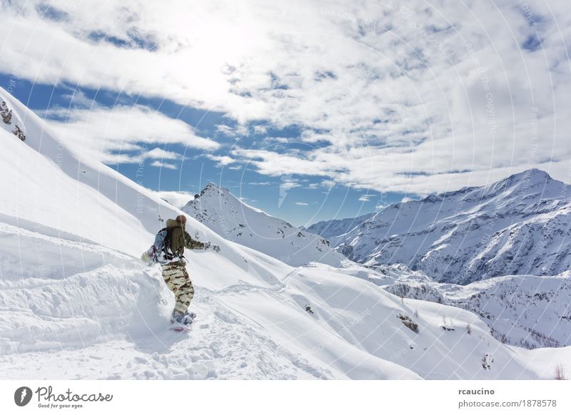Snowboarder geht bergab über eine verschneite Berglandschaft Ferien & Urlaub & Reisen Tourismus Winter Schnee Berge u. Gebirge Sport Skifahren Skipiste Junge 1