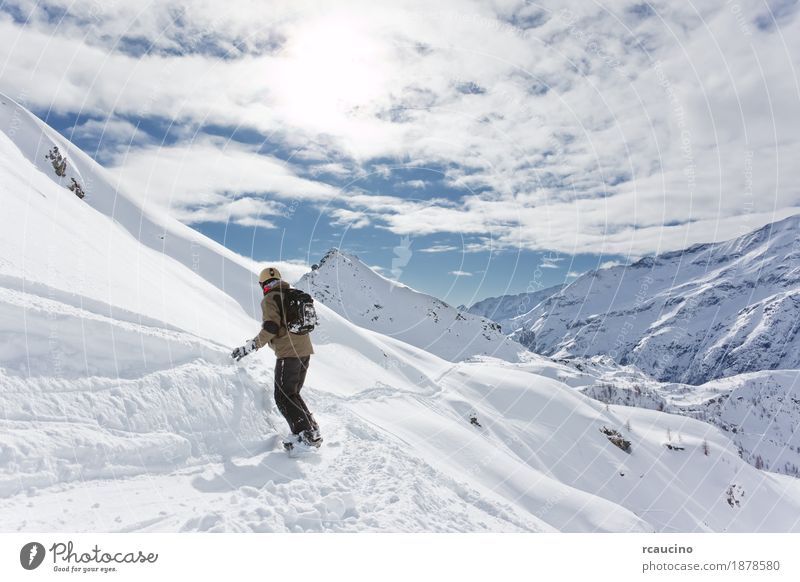 Snowboarder geht bergab über eine verschneite Berglandschaft Ferien & Urlaub & Reisen Winter Schnee Berge u. Gebirge Sport Skifahren Junge Landschaft Himmel