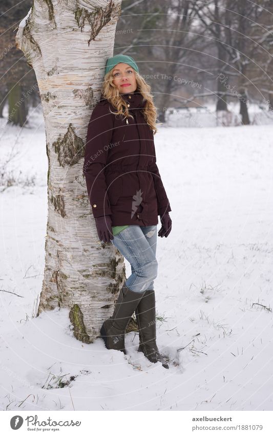 woman leaning against tree in winter Lifestyle Freizeit & Hobby Winter Schnee Mensch feminin Frau Erwachsene 1 30-45 Jahre Natur Baum Park Wald Mode Jeanshose