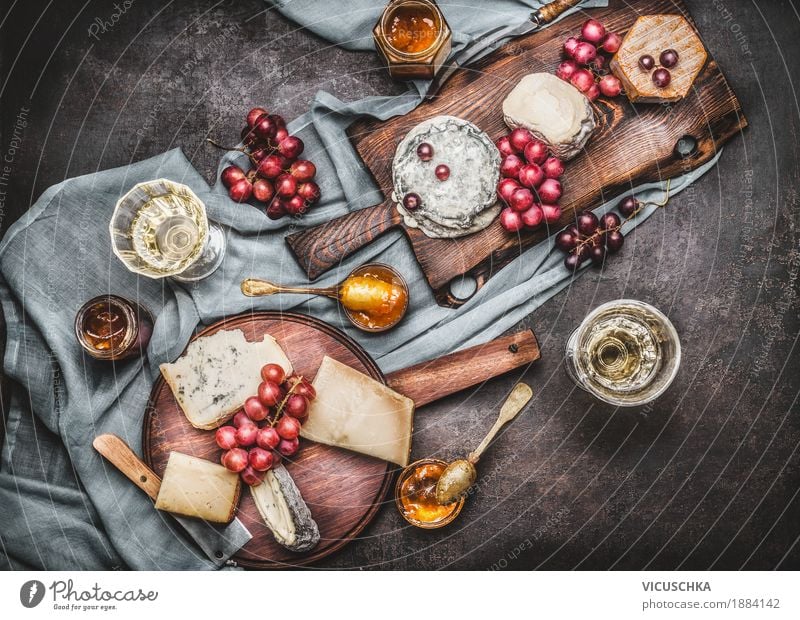 Verschiedene Käse auf Schneidebrettern mit Trauben und Wein Lebensmittel Milcherzeugnisse Frucht Dessert Ernährung Büffet Brunch Festessen Getränk Geschirr