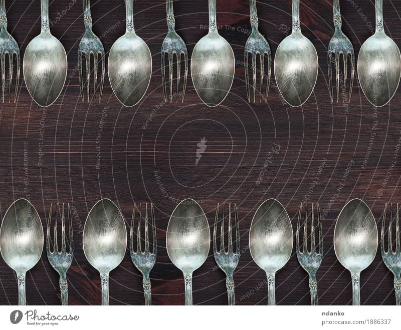Hölzerner Hintergrund mit Weinleselöffeln und -gabeln Abendessen Besteck Gabel Löffel Tisch Küche Werkzeug Holz Metall Stahl alt oben retro braun weiß