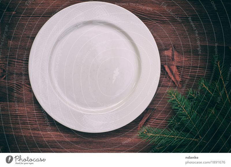 Weiße leere Platte mit einer grünen Niederlassung der Fichte Abendessen Geschirr Teller Tisch Küche Weihnachten & Advent Silvester u. Neujahr Holz alt oben