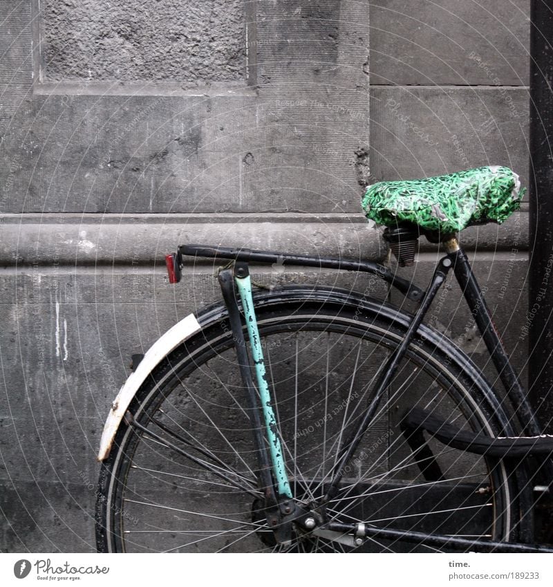 Drahtesel Fahrrad Rad Fahrradsattel Sattel Metall Metallwaren Gestänge Fahrradrahmen Schutzblech Mauer Sandstein Außenaufnahme Plastiktüte Regenschutz Speichen