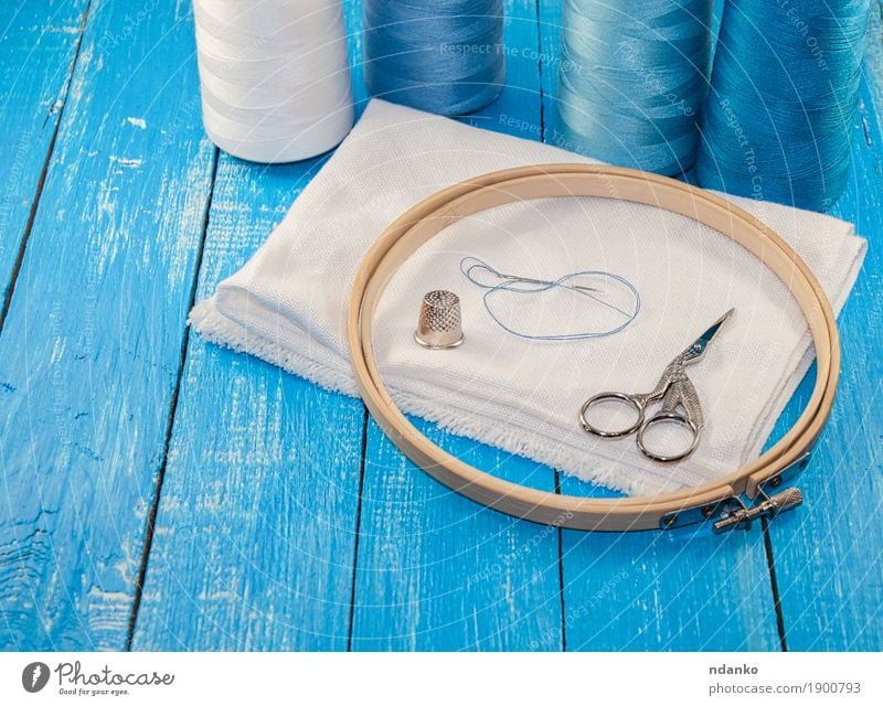 Threads in Spulen mit weißem Tuch für die Stickerei Freizeit & Hobby Arbeitsplatz Industrie Schere Menschengruppe Stoff Holz blau Faser Nähen Reihe Textilien