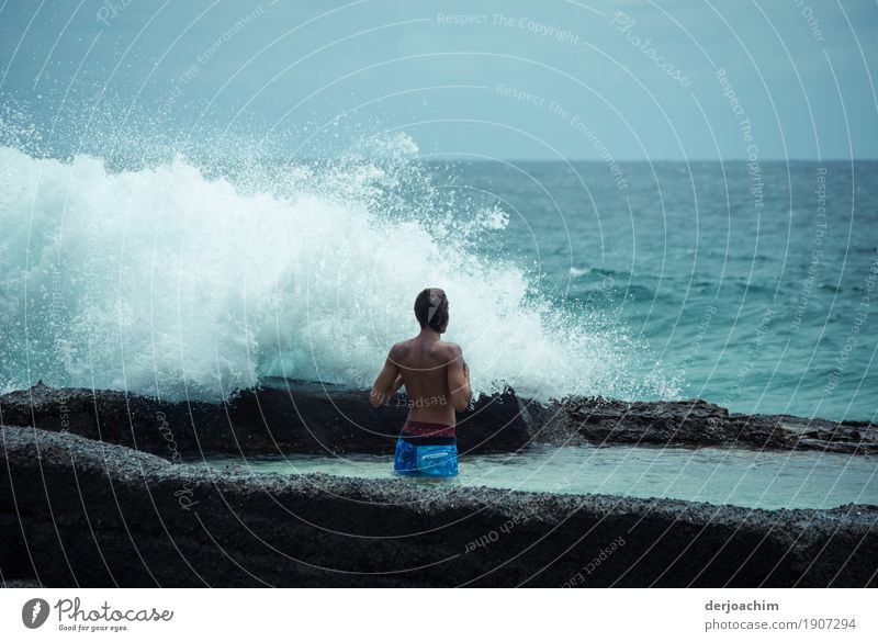 Öko Dusche. Ein Mann steht am Strand und wird von einer Welle umspült. Ein Tag im Januar am Pacific Freude Fitness Wellness Freizeit & Hobby Ausflug Wassersport
