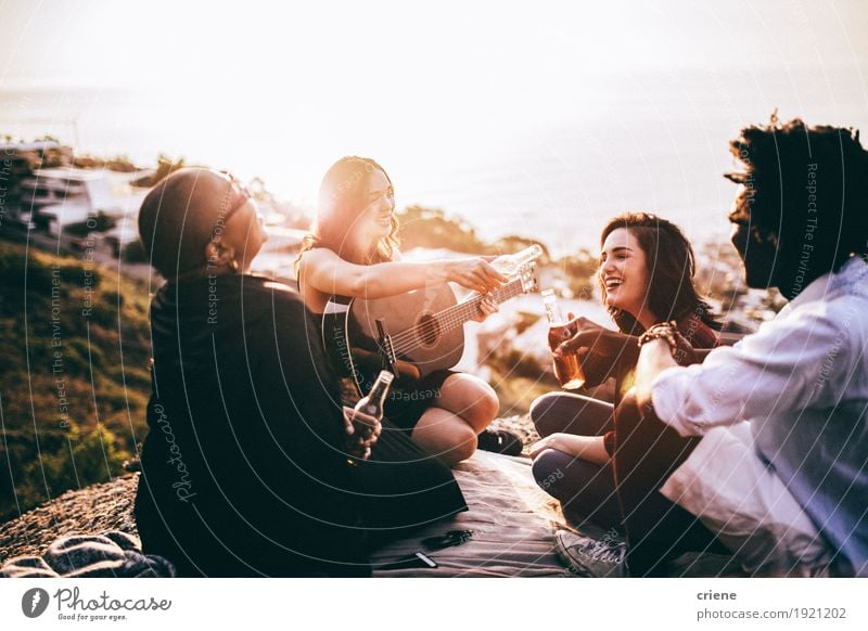 Gruppe Freunde, die Getränke genießen und Gitarre spielen Alkohol Bier Flasche Lifestyle Musik sprechen Freundschaft Erwachsene Menschengruppe hören Lächeln