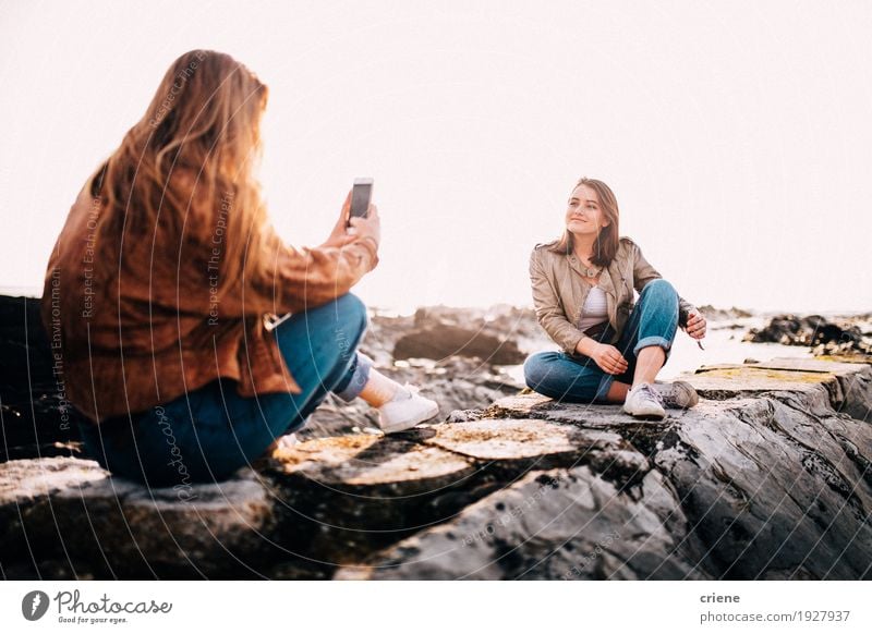 Jugendlichmädchen, das Foto mit Smartphone ihres Freundes macht Lifestyle Freude Strand Meer Telefon Handy PDA Fotokamera Technik & Technologie