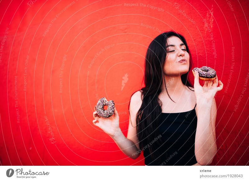 Junges glückliches kaukasisches Mädchen, das Schokoladenschaumgummiringe isst Lebensmittel Kuchen Dessert Süßwaren Essen Diät Fastfood Lifestyle Freude Mensch