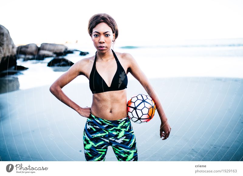Junger weiblicher afrikanischer Athlet auf Strand mit Fußball Lifestyle Körper sportlich Fitness Leben Wohlgefühl Freizeit & Hobby Meer Wellen Sport feminin