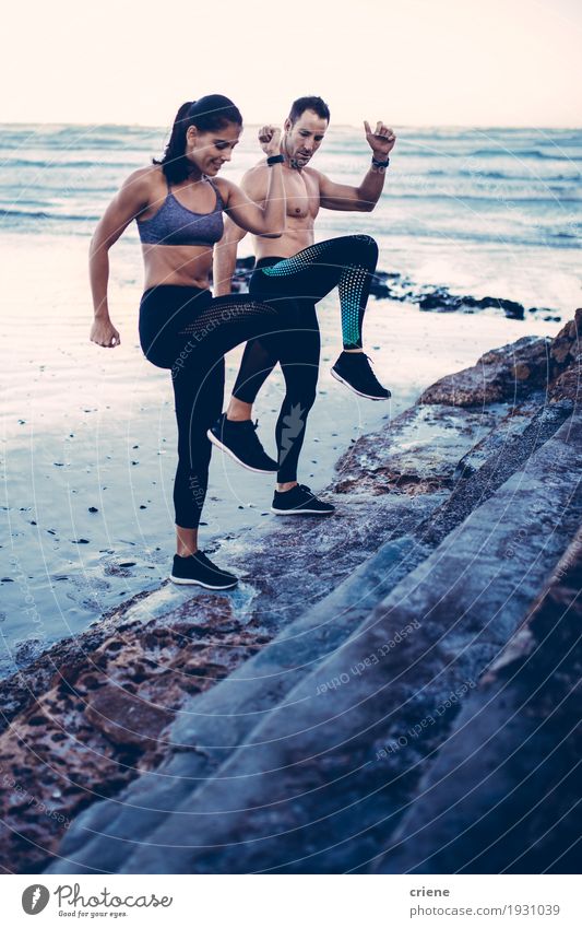Sportliche Paare, die zusammen auf dem Strand ausbilden Lifestyle Freude Körper Meer Wellen Fitness Sport-Training Frau Erwachsene Mann Jugendliche Sand