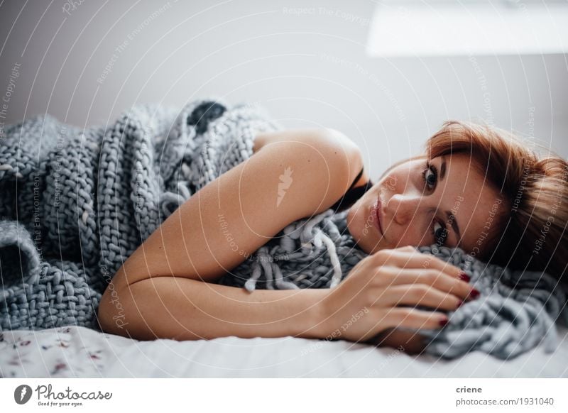 Junge kaukasische Frauen, die in das Bett betrachtet Kamera legen Lifestyle Wohlgefühl Häusliches Leben Wohnung Raum Schlafzimmer Mensch feminin Junge Frau