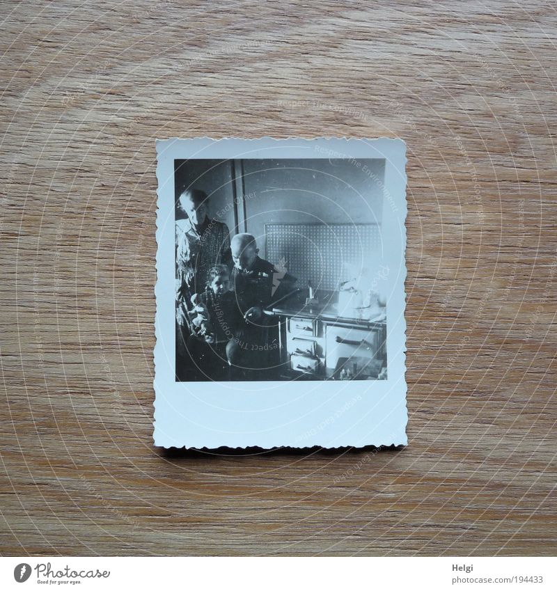Foto eines Fotos in einer historischen Küche  mit Opa, Mutter, Kind und Puppe Mensch maskulin Frau Erwachsene Mann Weiblicher Senior Männlicher Senior Kindheit