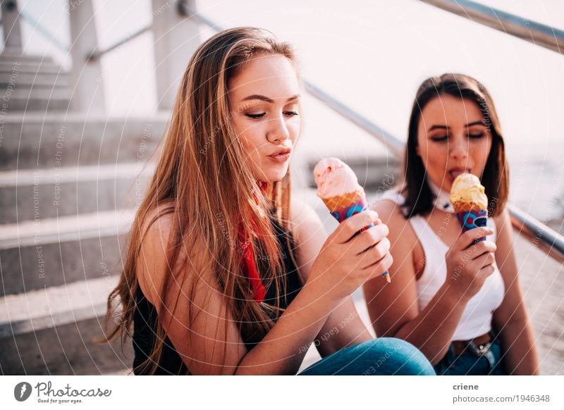 Teenagermädchen der besten Freunde, die Eiscreme auf dem Strand essen Lebensmittel Dessert Speiseeis Süßwaren Essen Lifestyle Freude Ferien & Urlaub & Reisen