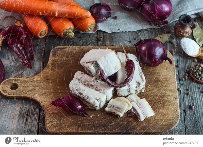 Salz-Schweinefleisch-Speck auf einem Küchenbrett Lebensmittel Gemüse Kräuter & Gewürze Essen Löffel Tisch Stoff frisch natürlich braun grau orange rot Fett