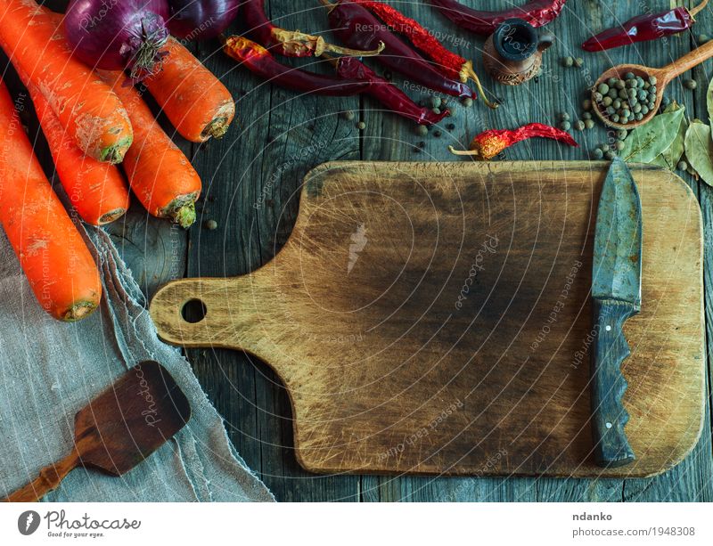 braunes Schneidebrett mit einem Messer Lebensmittel Gemüse Frucht Kräuter & Gewürze Essen Bioprodukte Vegetarische Ernährung Löffel Gesunde Ernährung Tisch