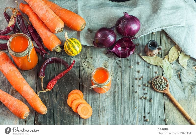 Frische Karotten und Karottensaft in einem Glasbehälter Gemüse Kräuter & Gewürze Vegetarische Ernährung Diät Getränk Saft Tisch Küche Natur Holz alt Essen
