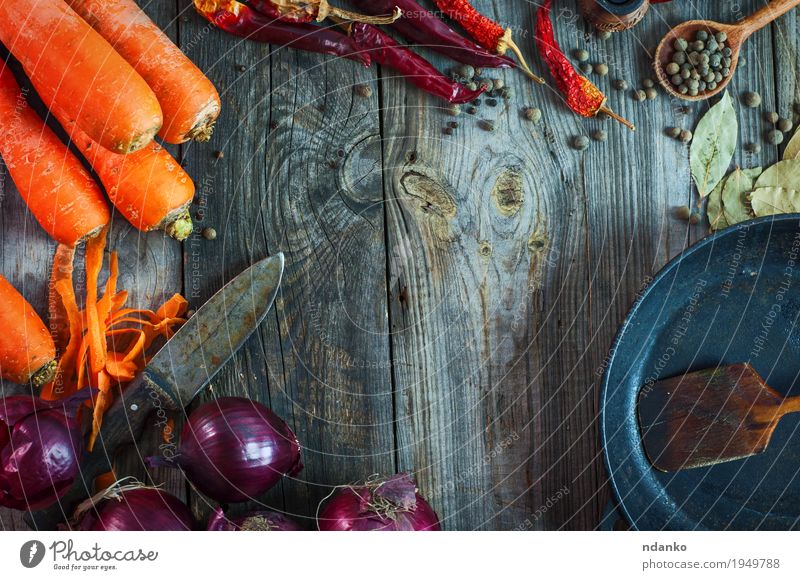 Frische Karotten und rote Zwiebel mit einer Bratpfanne Gemüse Frucht Kräuter & Gewürze Vegetarische Ernährung Pfanne Löffel Tisch Küche Holz Metall alt Essen