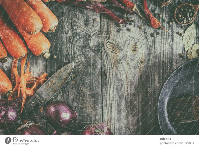 Frische Karotten und rote Zwiebel mit einer Bratpfanne Lebensmittel Gemüse Kräuter & Gewürze Vegetarische Ernährung Pfanne Löffel Tisch Küche Holz alt frisch