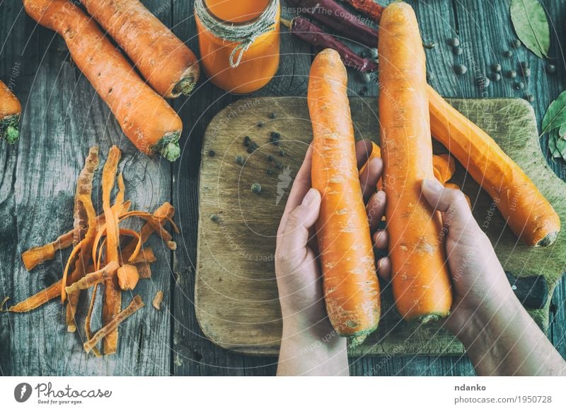 Zwei große reife Karotten liegen in den weiblichen Händen Gemüse Kräuter & Gewürze Ernährung Essen Vegetarische Ernährung Diät Getränk Saft Messer Körper Tisch