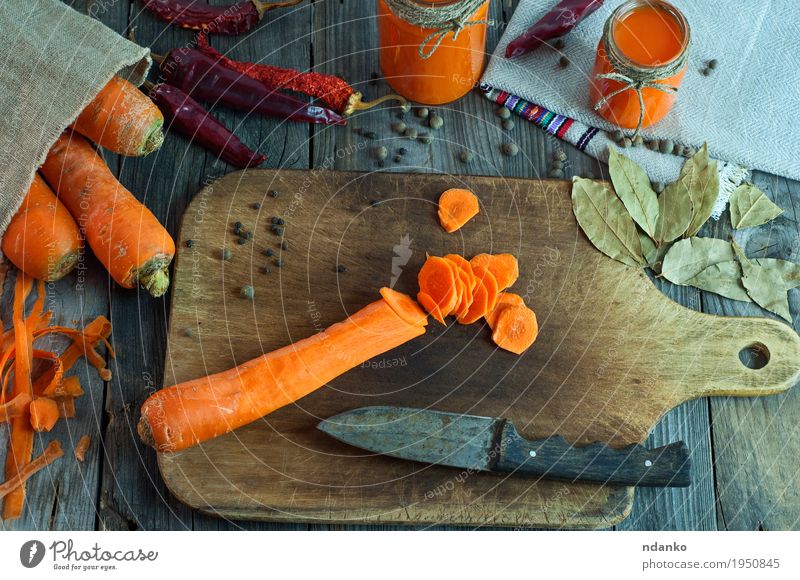 In runde Scheiben von großen frischen Karotten schneiden Lebensmittel Gemüse Kräuter & Gewürze Ernährung Bioprodukte Vegetarische Ernährung Messer Löffel
