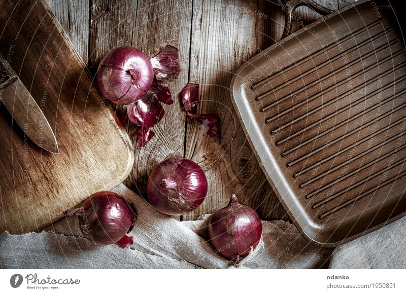 Schwarze Wanne für den Grill und die rote Zwiebel auf einer Holzoberfläche Gemüse Vegetarische Ernährung Pfanne Messer Küche Stoff Metall alt dunkel frisch