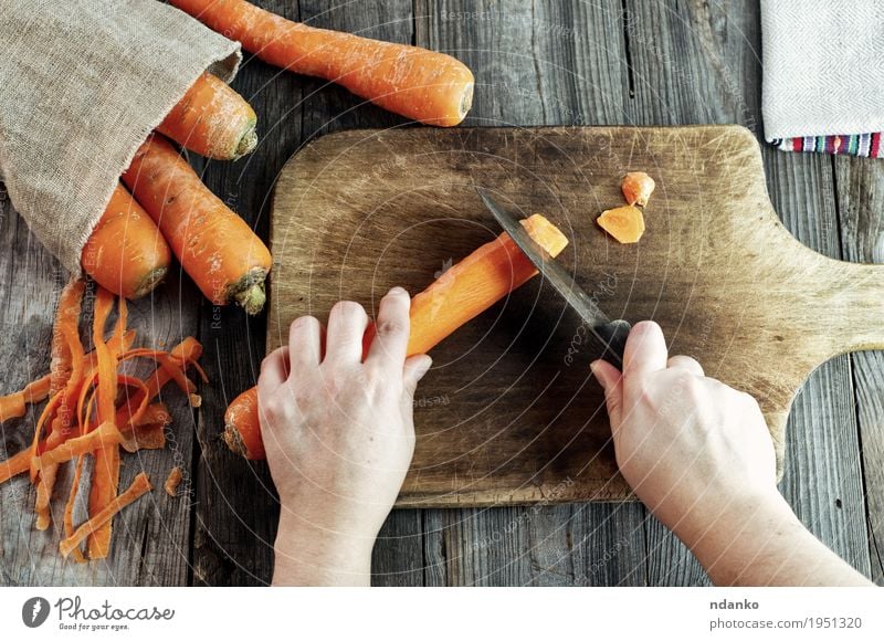Prozess des Schneidens Scheiben Karotten auf einem Küchenbrett Lebensmittel Gemüse Ernährung Vegetarische Ernährung Diät Messer Körper Gesunde Ernährung Tisch