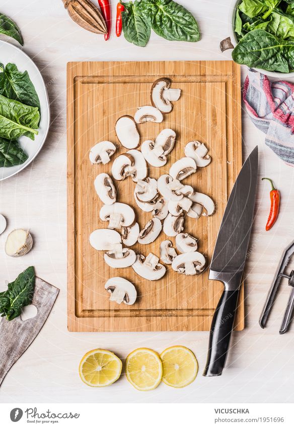 Geschnittene Champignons auf Schneidebrett mit Küchenmesser Lebensmittel Gemüse Ernährung Bioprodukte Vegetarische Ernährung Diät Geschirr Messer Stil Design
